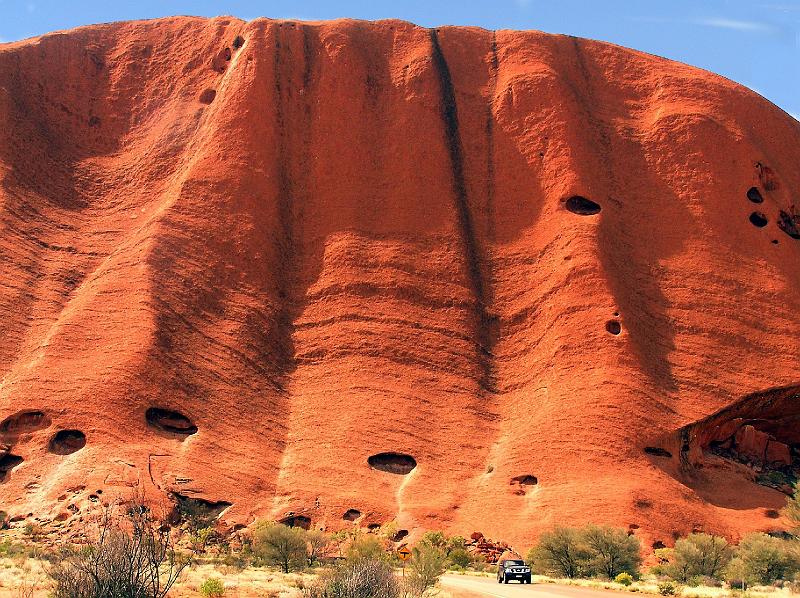 uluru2.jpg - Der Uluru ist etwa 3,0 km lang, bis zu 2,0 km breit und hat einen Umfang von rund 10 km. Der Gipfel befindet sich auf einer absoluten Hoehe von 869 m und hebt sich damit rund 350 m von der Duenenlandschaft Zentralaustraliens ab.