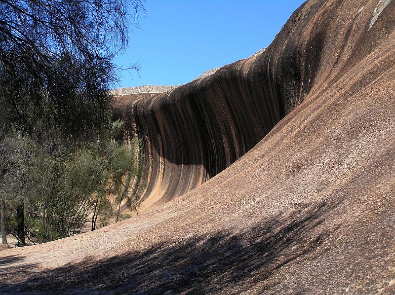 waverock2.jpg - Verschiedene chemische Prozesse bei der Beruehrung mit Wasser gestalteten die den Wave Rock charakterisierenden vertikalen Streifen. Ausgewaschene Karbonate bilden die schwarzen, Eisenhydroxid die roten Streifen.